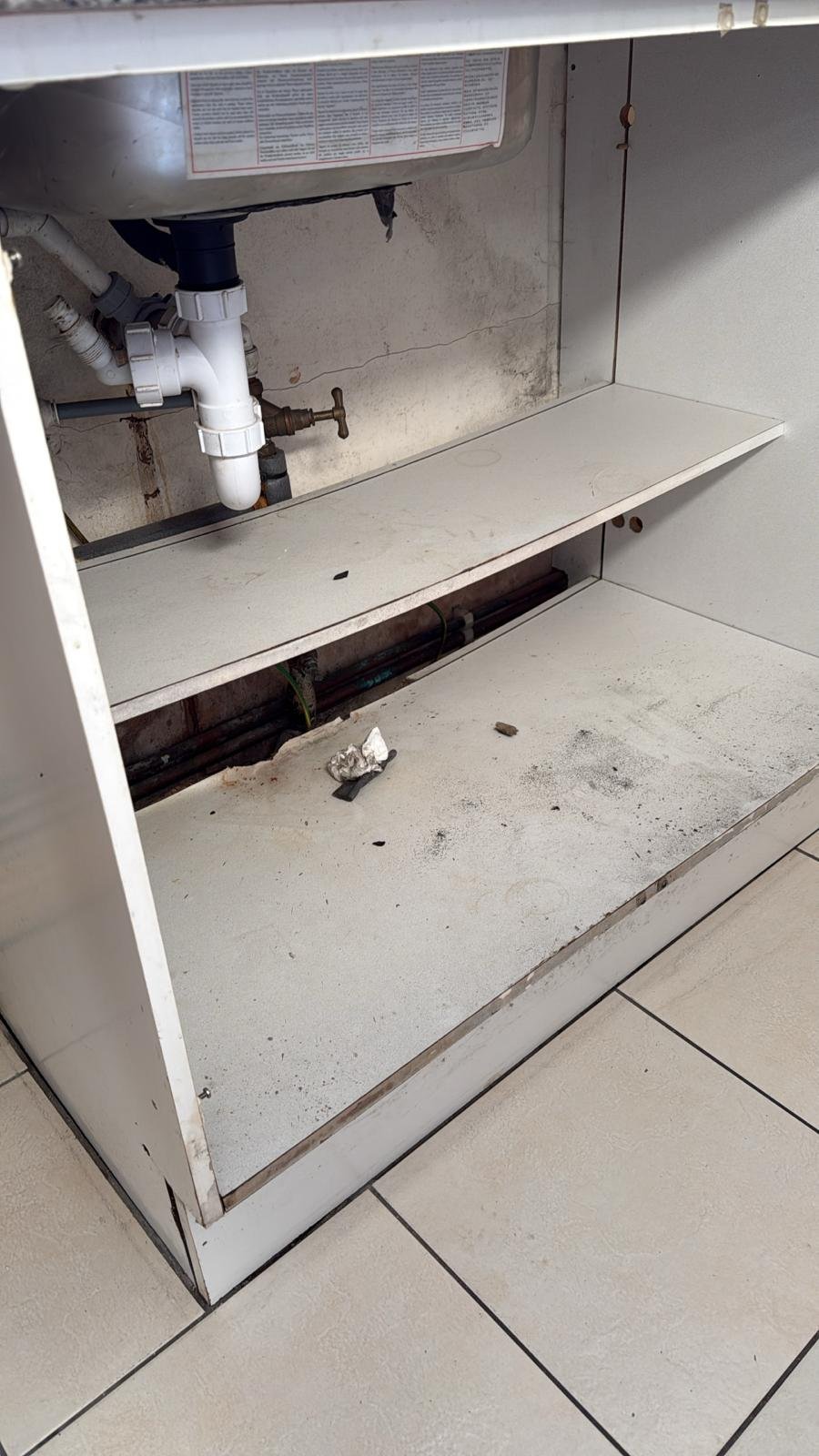 Before: rotten kitchen cabinet and leaking stop tap