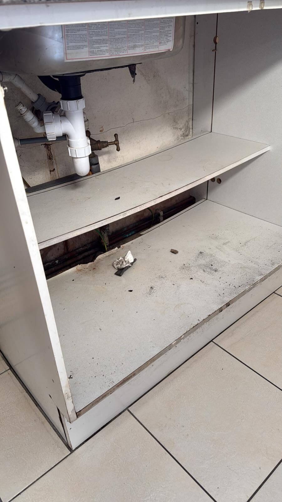 Before: rotten kitchen cabinet and leaking stop tap